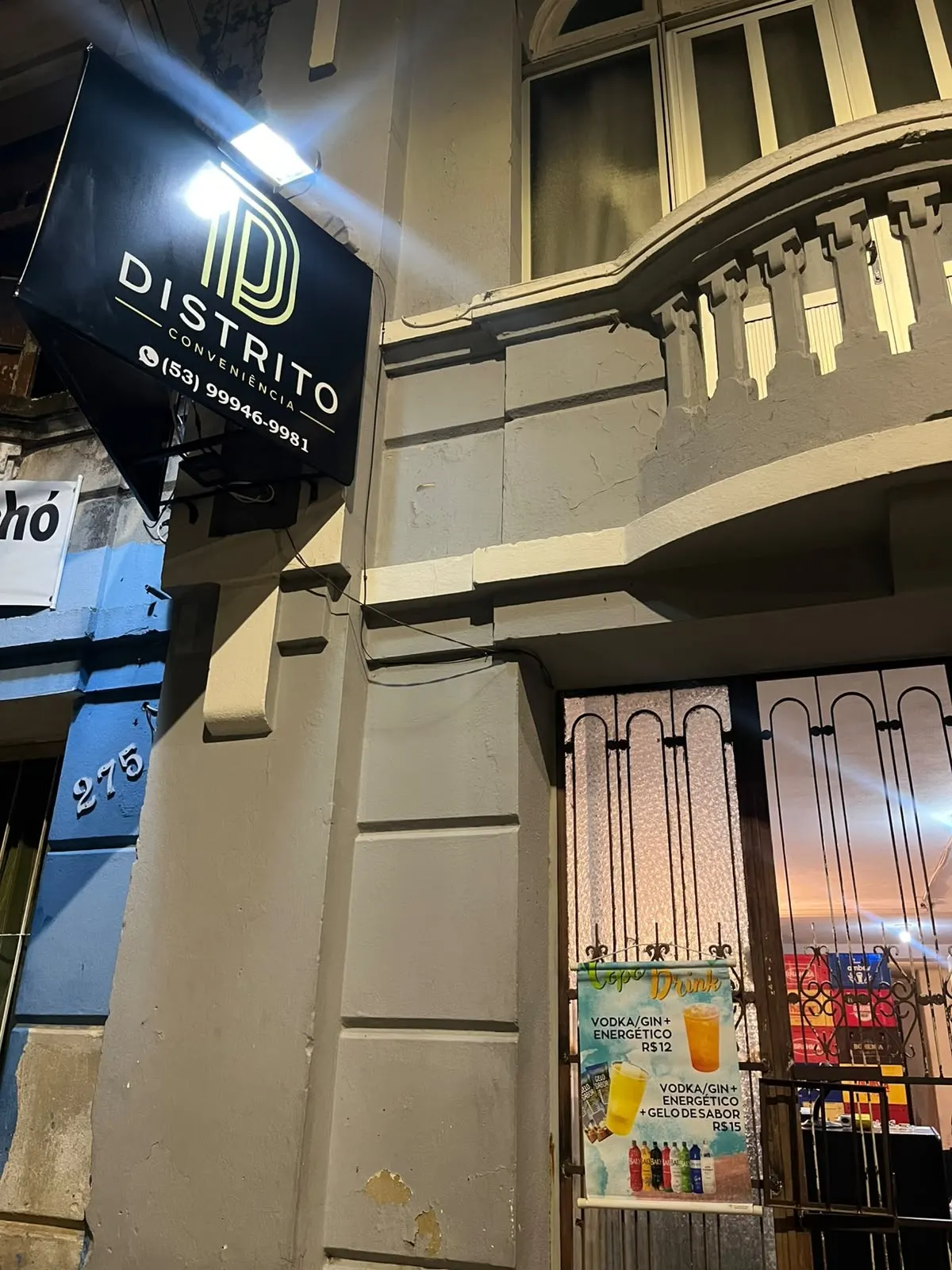 Fachada da Distrito Conveniência à noite